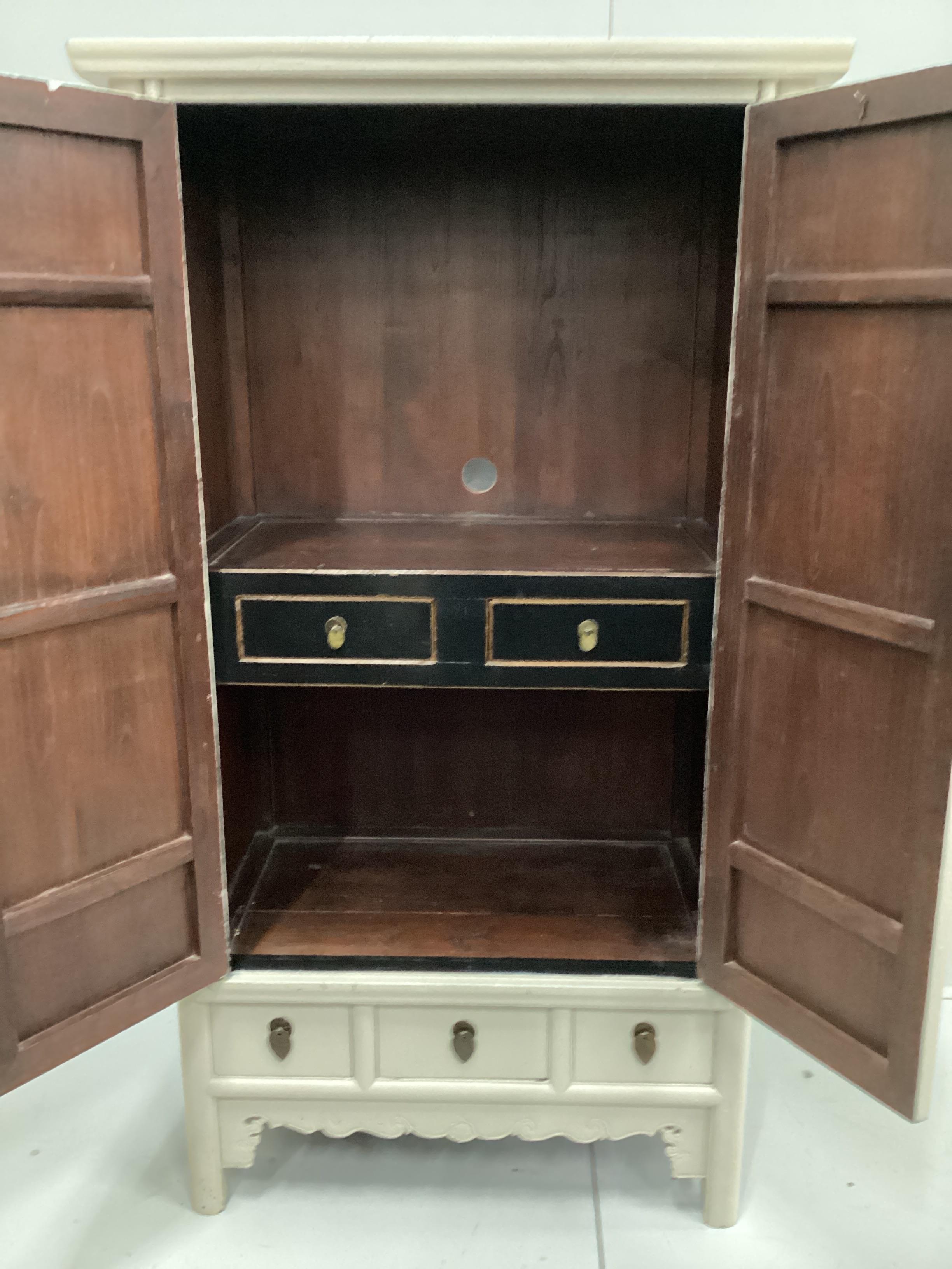 A Chinese elm two door side cabinet, later painted, width 99cm, depth 64cm, height 180cm